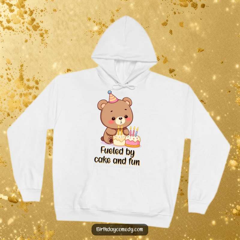 Funny birthday hoodie showcasing a cute bear with a party hat blowing out birthday candles on a miniature cake, embodying pure celebration.