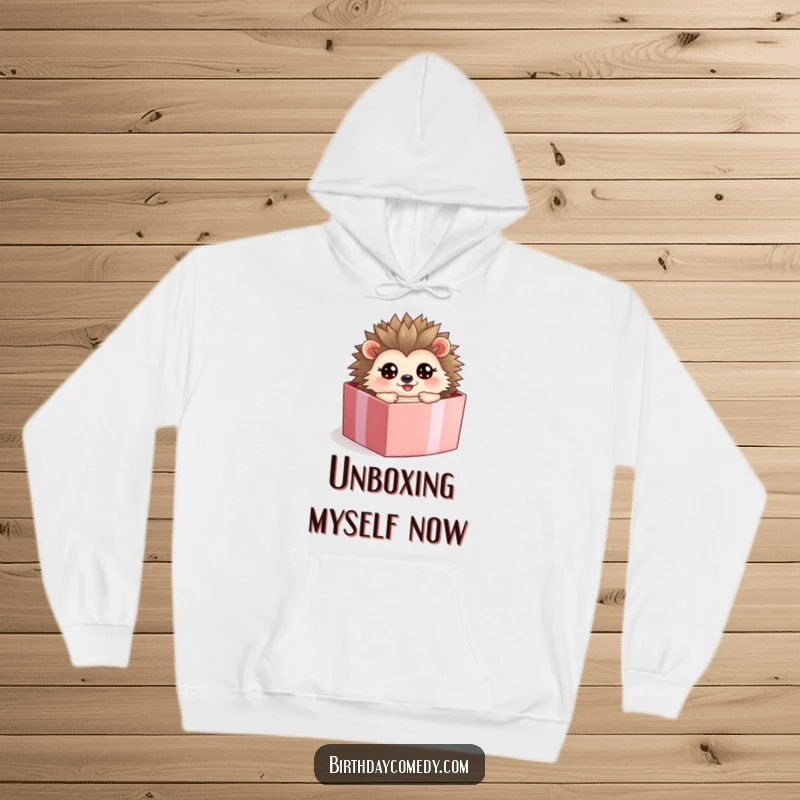 Funny hedgehog hoodie, a happy character rolling inside a present box with wide, excited eyes.