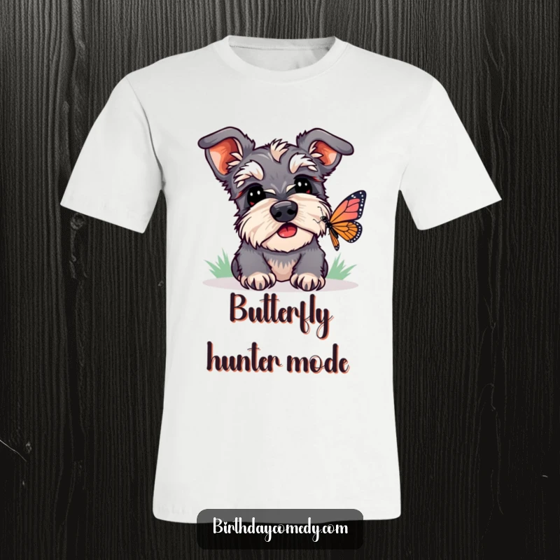 Funny schnauzer t-shirt featuring a dog intently watching a butterfly with perked ears, a humorous and captivating design.