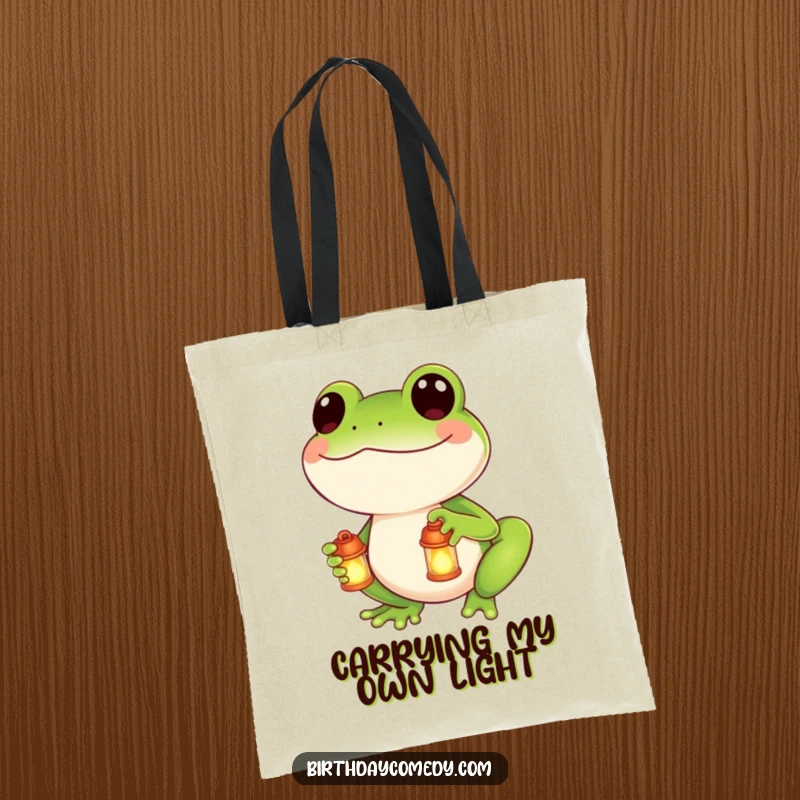 Funny tote bag featuring a smiling frog holding a small, illuminated lantern, perfect for carrying daily essentials with a smile.